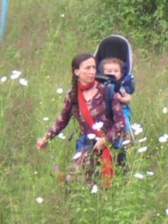 Isabelle walking over a mountain with her baby on her back.