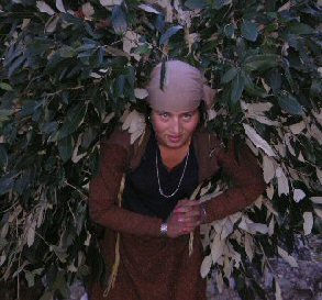 Indian woman carrying load of brush on back